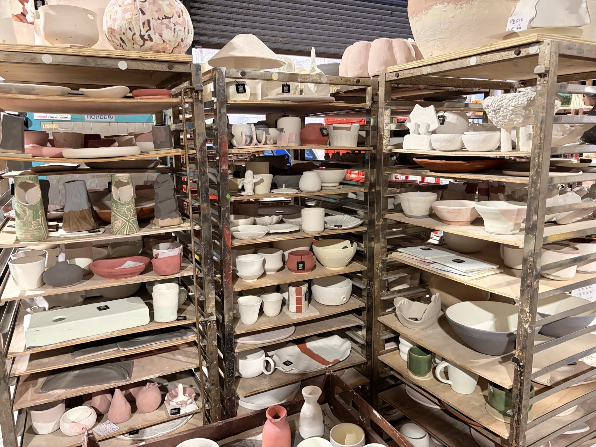 Shelves of finished pottery at a busy studio, waiting for collection.