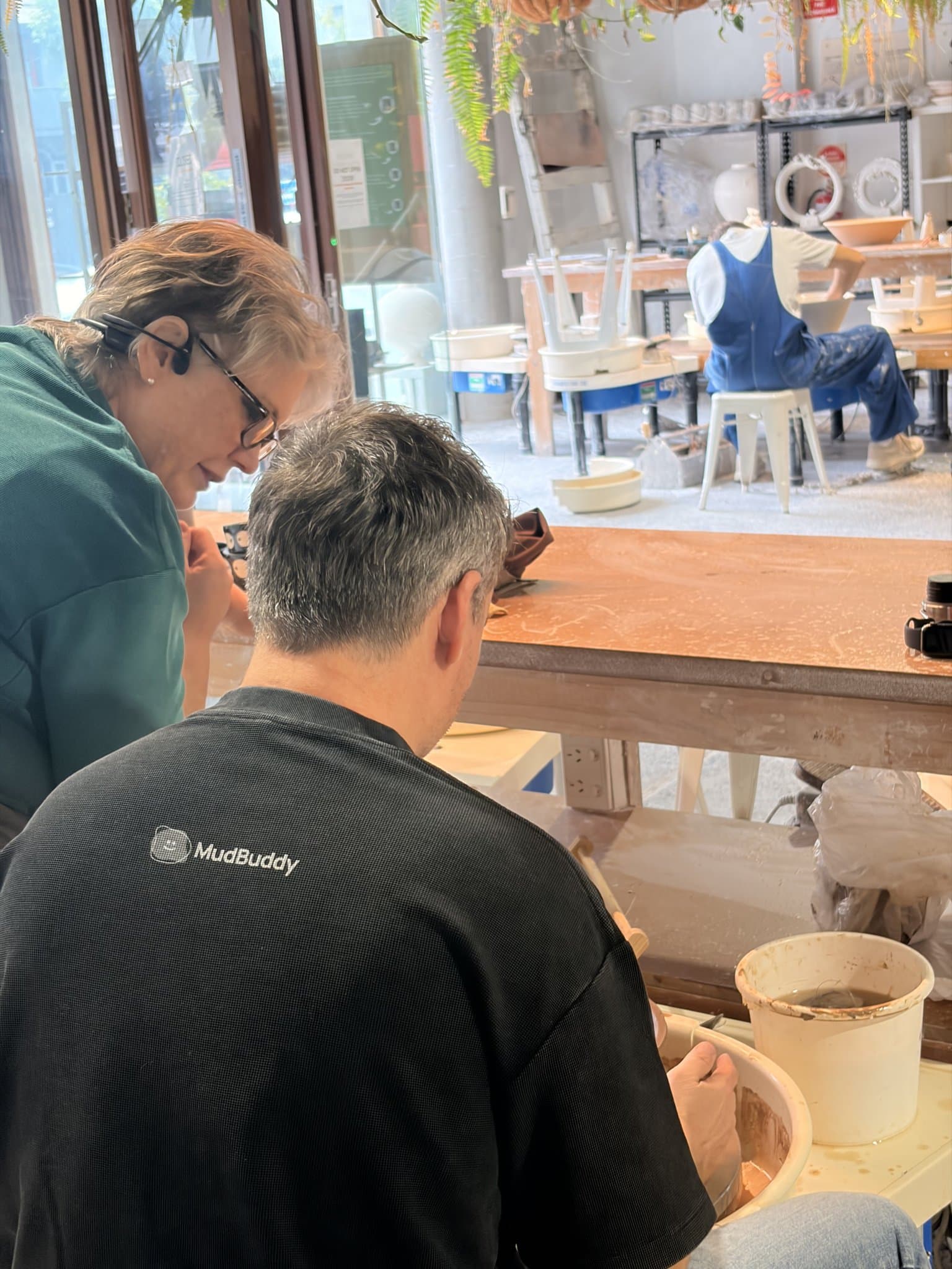 A studio team member helping a member at the bench.